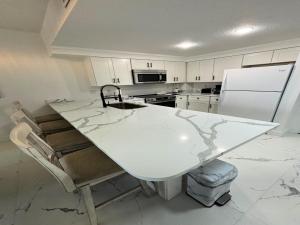 a kitchen with a white counter and a white refrigerator at Totally Updated 1 BR Deluxe Jacuzzi Suite - Wyndham Ocean Walk 2429 - Vacation in Resort luxury in Daytona Beach