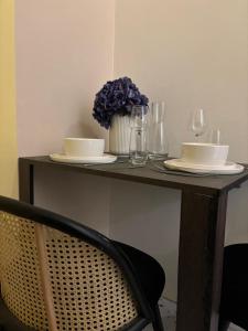 a table with plates and glasses and a vase of flowers at Your Haven of Peace! in Brussels