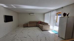a living room with a couch and a television at Brisa Mar in Canavieiras