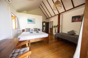 a bedroom with a bed and a couch in it at The Point SurfHouse 3 meals included in Katiet