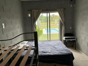 a bedroom with a bed and a window with a pool at El quincho in Villa María +4 photos