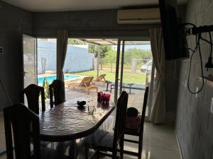 a dining room with a table and chairs and a pool at El quincho in Villa María