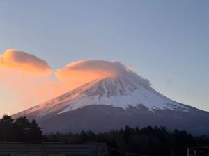 a snow covered mountain with clouds in the sky at Ondolphin in Narusawa