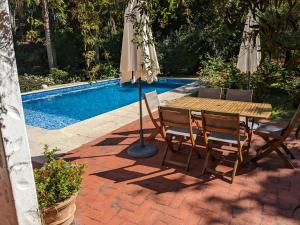 a table and chairs with an umbrella next to a pool at Casa Pura Vida in Punta del Este
