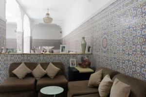 a living room with two couches and a tile wall at Dar Al Hajja Fatima in Rabat
