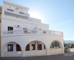 ein weißes Gebäude mit Balkon darüber in der Unterkunft White House Hotel-Apart in Karpathos
