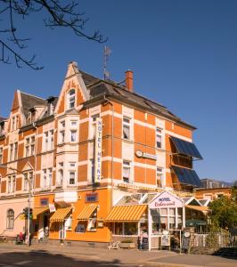 ein großes orangenes Gebäude an der Ecke einer Straße in der Unterkunft Hotel Heinz in Plauen