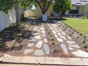 a walkway with rocks and a sign in a yard at Owl Place in Hahndorf in Hahndorf