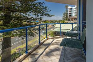 a balcony with two chairs and a view of a street at Heritage 301 in Tuncurry
