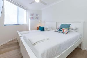 a white bedroom with a large white bed at Heritage 301 in Tuncurry +8 photos