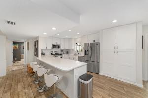 a kitchen with white cabinets and a large white counter at Cleopatra's Sunset in Ocala