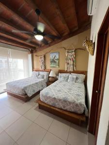 Un dormitorio con dos camas y un techo. en Penthouse on the shore of the pacific in Bucerias, en Bucerías