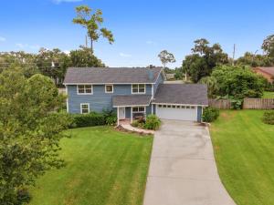 a blue house with a driveway and a yard at Cleopatra's Sunset in Ocala