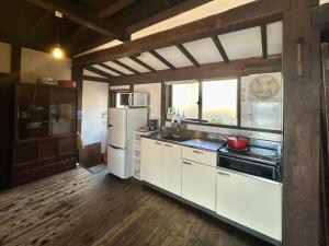 a kitchen with white appliances and a wooden floor at もしもしの家 in Koshu