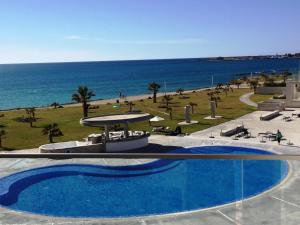a swimming pool with a view of the ocean at Amphora Hotel & Suites in Paphos