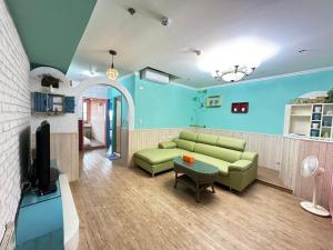 a living room with a couch and a tv at CT Theme Suite in Kaohsiung