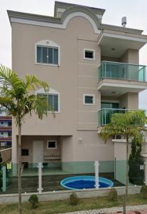 a building with palm trees in front of it at AP completo na Praia de Palmas, SC in Governador Celso Ramos