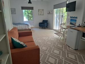 een woonkamer met een bank en een keuken bij Forest view bungalow in Nambucca Heads