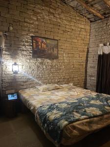a large bed in a room with a brick wall at Virasat homestay in Chanderi +18 photos