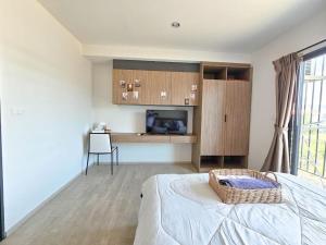 a bedroom with a bed and a desk with a television at La Casita Condo Hua Hin 6 in Hua Hin