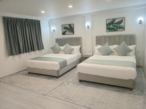 una camera da letto con due letti e una finestra di Hibiscus Suites And Residences a Nadi Altre 37 foto
