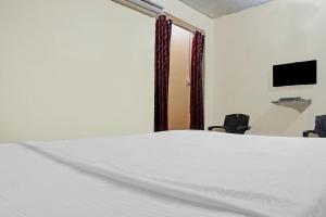 a bedroom with a white bed and two chairs at Hotel O Sai Lodge in Méribel Village +38 photos