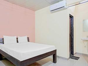 a white bedroom with a bed and a sink at Hotel O Sai Lodge in Méribel Village