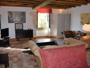 a living room with a couch and a table at Moulin atypique du XVème siècle avec jardin clos - FR-1-381-483 in Arpheuilles