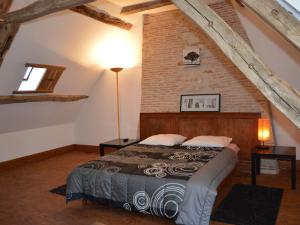 a bedroom with a bed and a brick wall at Moulin atypique du XVème siècle avec jardin clos - FR-1-381-483 in Arpheuilles