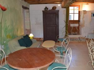 a living room with a table and chairs and a couch at Moulin atypique du XVème siècle avec jardin clos - FR-1-381-483 in Arpheuilles