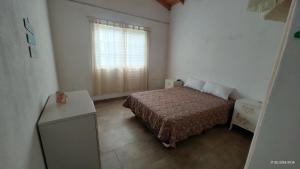 een kleine slaapkamer met een bed en een raam bij La Arbolada in Mar del Plata