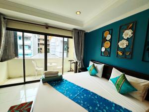 a bedroom with a large bed with blue walls at Sky Silk Decoration House in Patong Beach