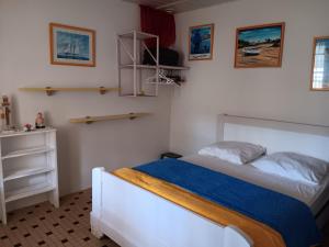 Maisonnette Individuelle Proche Centre Ville à La Faute-sur-Mer - FR-1-476-131 في لا فاوت سور مير: غرفة نوم مع سرير وبطانية زرقاء