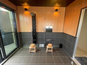 a bathroom with two stools in front of a shower at 徳治郎の宿 in Izumi-Sano +86 photos