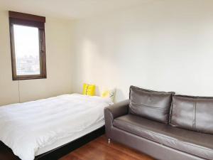 a bed and a couch in a room at 颯House 4 in Osaka