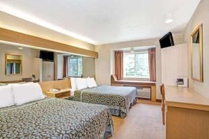 a hotel room with two beds and a window at Sturbridge Plaza Hotel in Sturbridge