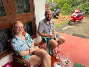 Ein Mann und eine Frau sitzen auf einer Veranda in der Unterkunft Villa iSoNet in Weligama