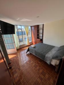 a bedroom with a bed and a large window at Apartamento Amplio con balcones Duitama in Duitama