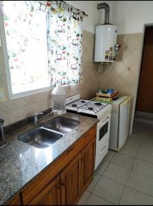 a kitchen with a sink and a stove and a window at Casa Bela in Villa Carlos Paz