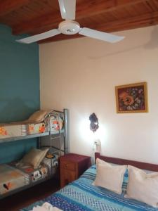 a bedroom with two bunk beds and a ceiling fan at Casa Bela in Villa Carlos Paz