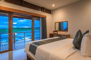 Un dormitorio con una cama y un balcón. en The Manik Kalisada, en Tegallengah