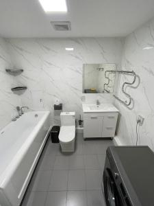 a bathroom with a tub sink and a toilet at In the central of Ulaanbaatar, Selbe Comfort Apartment, 9f 187 in Ulaanbaatar +37 photos