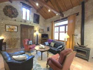 a living room with furniture and a stone wall at Maison de charme à Brantôme, animaux admis, parking inclus - FR-1-616-461 in Brantôme