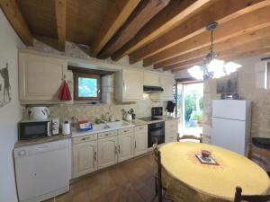 a kitchen with white cabinets and a table in it at Maison de charme à Brantôme, animaux admis, parking inclus - FR-1-616-461 in Brantôme