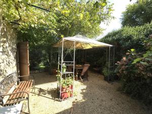 a gazebo with a table and a bench in a garden at Maison de charme à Brantôme, animaux admis, parking inclus - FR-1-616-461 in Brantôme +5 photos