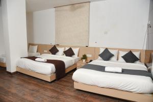two beds in a hotel room with two beds sidx sidx sidx at Hotel The Emporio A Boutique Rooms Near Anand Vihar Vaishali Ghaziabad in Ghaziabad