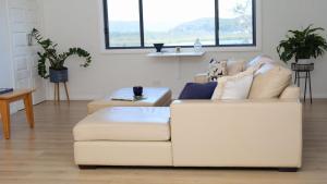 a living room with a white couch and a table at Akoya Pearl Central Coast in Empire Bay