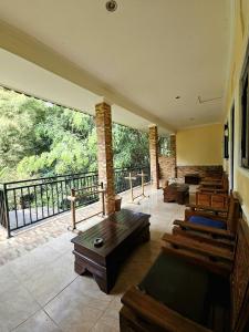 a room with benches and tables on a balcony at Classic House By Green View in Ubud