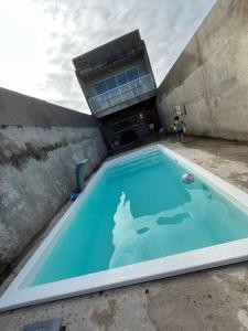 una piscina di fronte a un edificio di família Dias a Peruíbe
