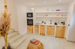 a kitchen with wooden cabinets and a black refrigerator at La Esquina 1B in Denia